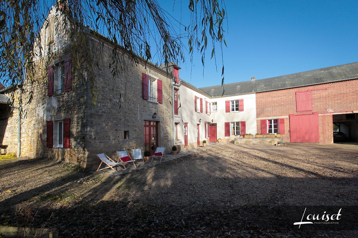 Une vue extérieure du gîte à la campagne, entouré de verdure, offrant un cadre idyllique pour des événements familiaux et d'entreprise.