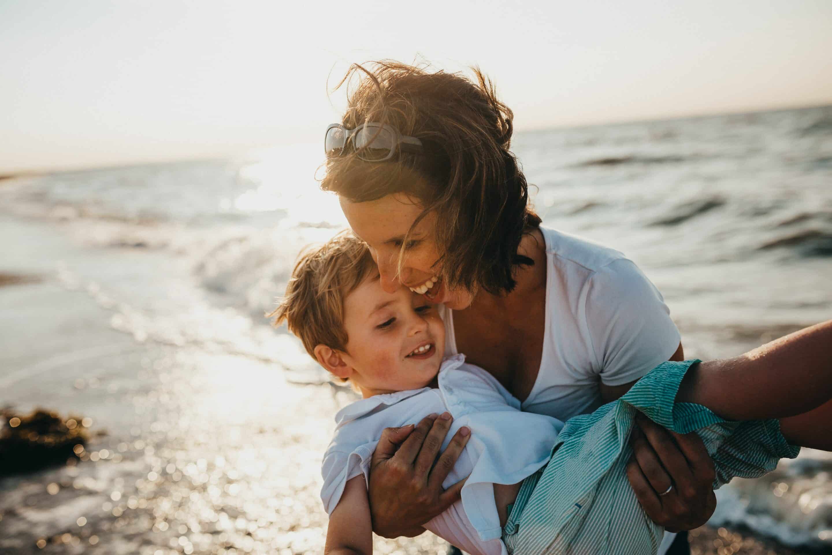 femme qui sourit avec son enfant dans les bras