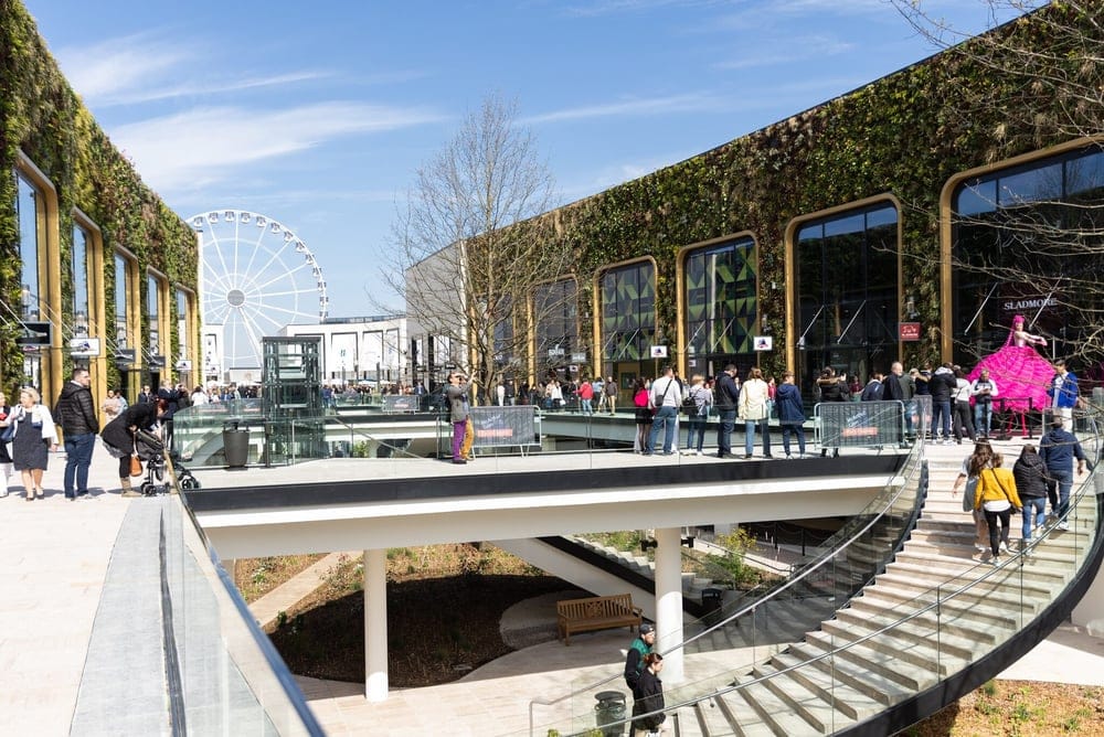 Buitenaanzicht van het Mac Arthur Glen Paris Giverny winkelcentrum, omgeven door de pittoreske charme van het Normandische platteland.