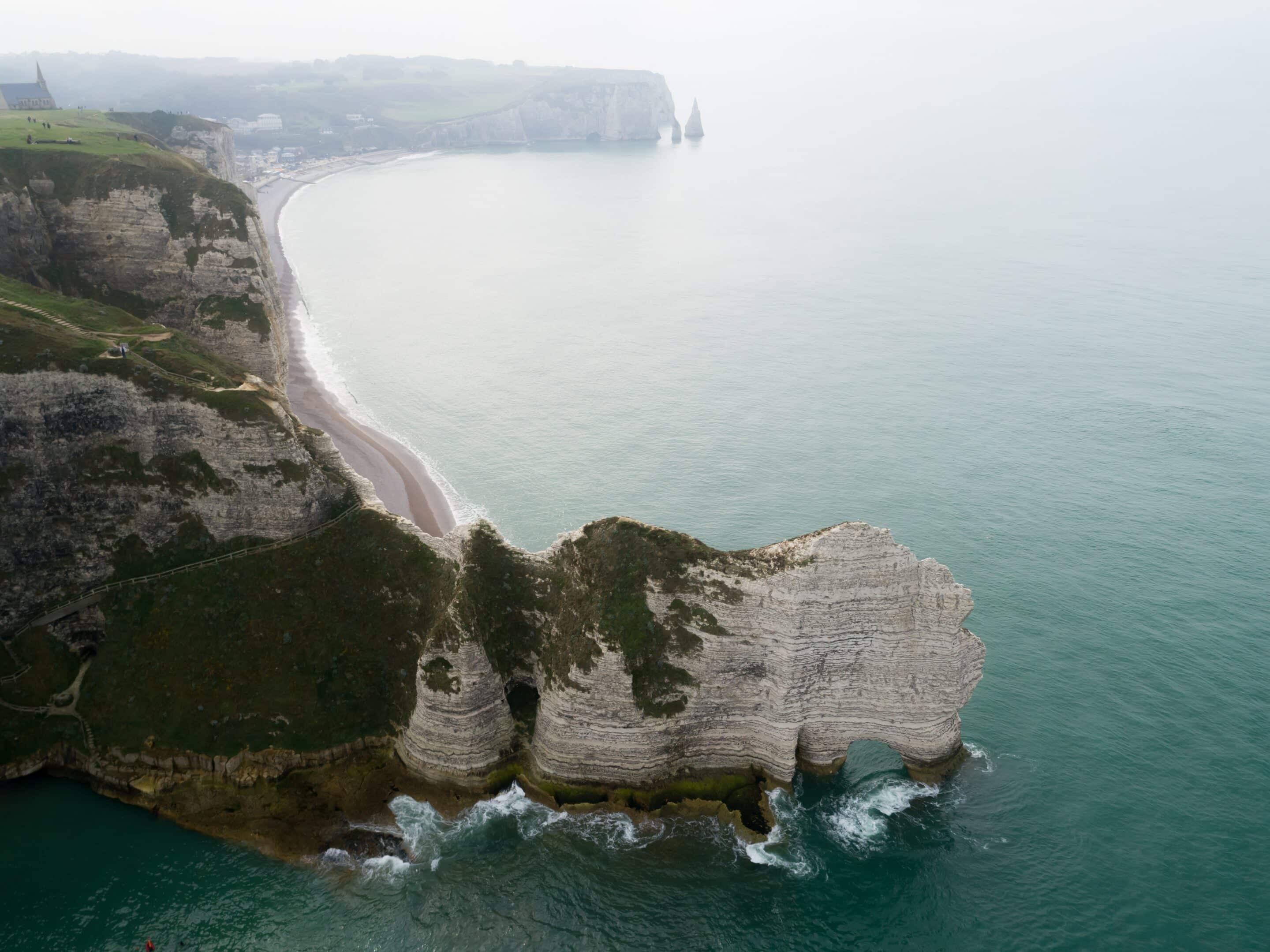 埃特雷塔特（Étretat）标志性悬崖的景观，展现了诺曼底海岸陆地与海洋交汇的壮观景象。